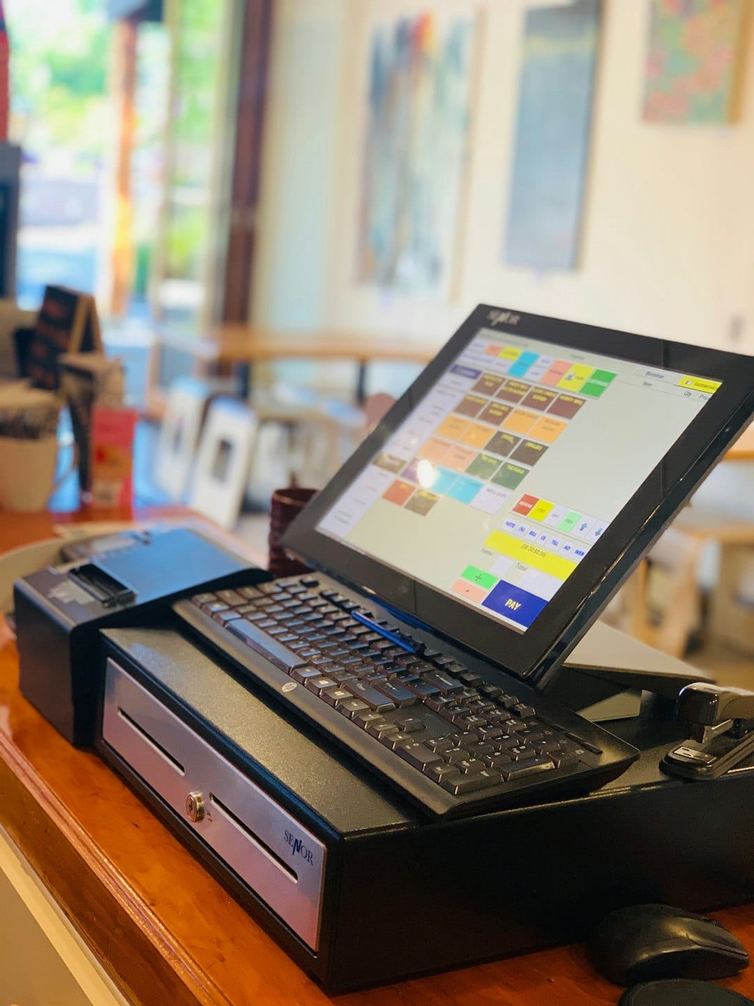 System POS na ladzie kawiarni gotowy do transakcji.